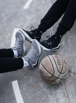 person in black pants and white nike basketball shoes